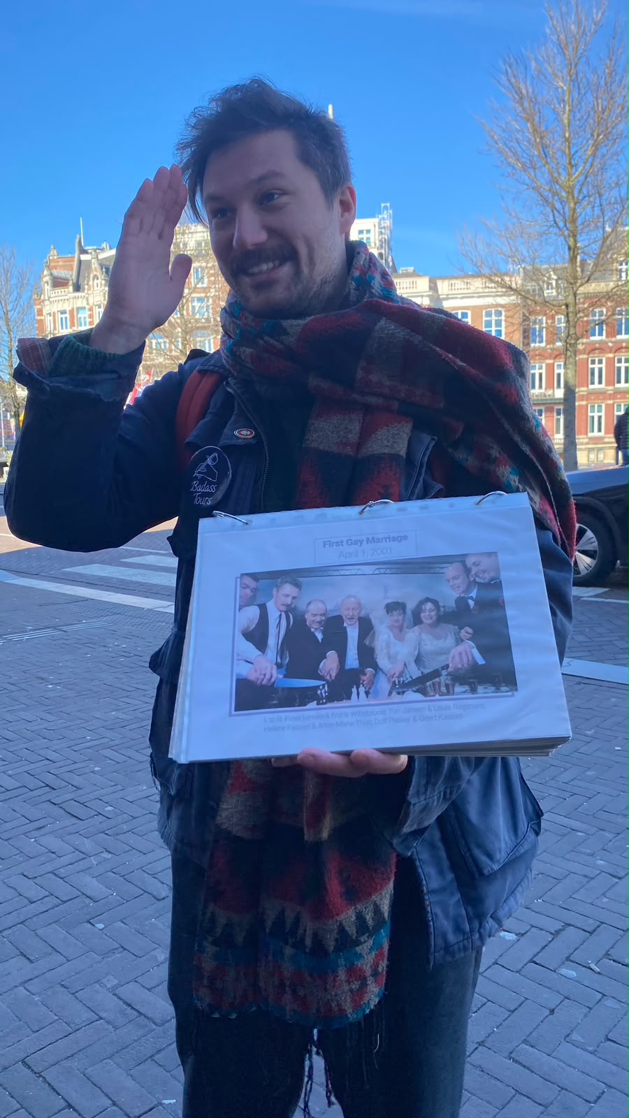 Tour guide from Badass Tours holding a photo of the first same-sex marriage, 1 April 2001