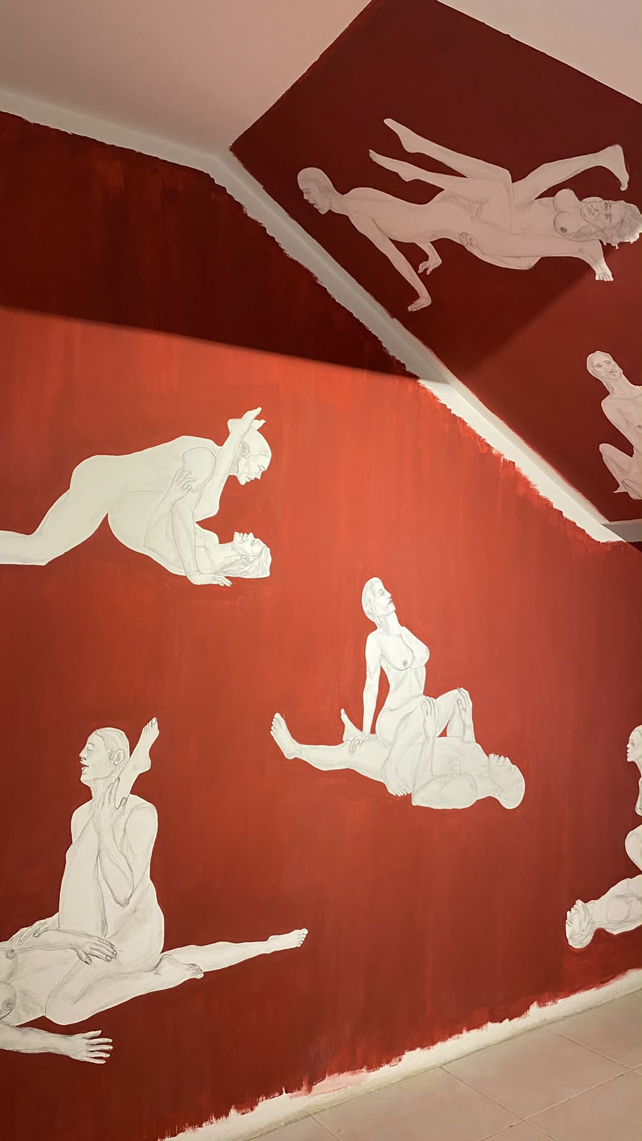 Red wall and ceiling painted with white figures in sexual positions