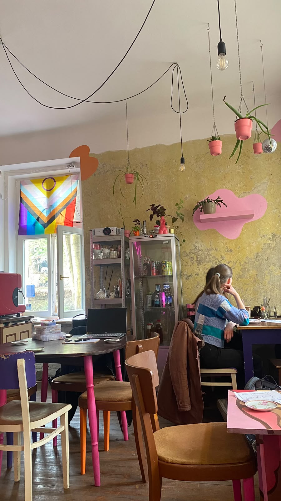 Colourful café with an intersex-inclusive Progress Pride flag in the window