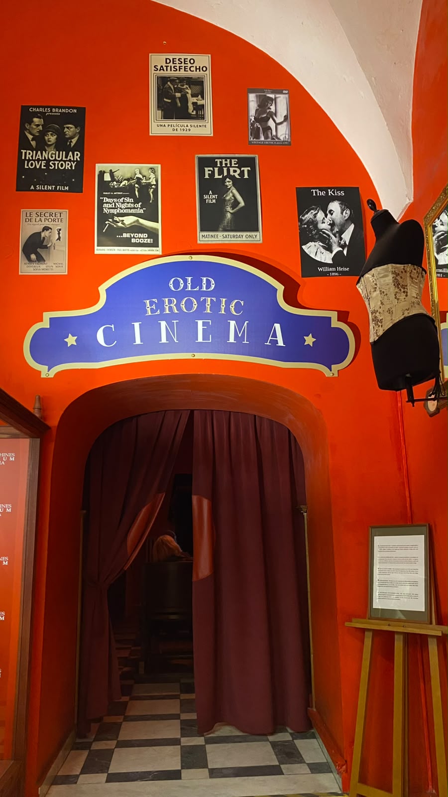 Entrance to the Old Erotic Cinema, with vintage erotic film posters on an orange wall